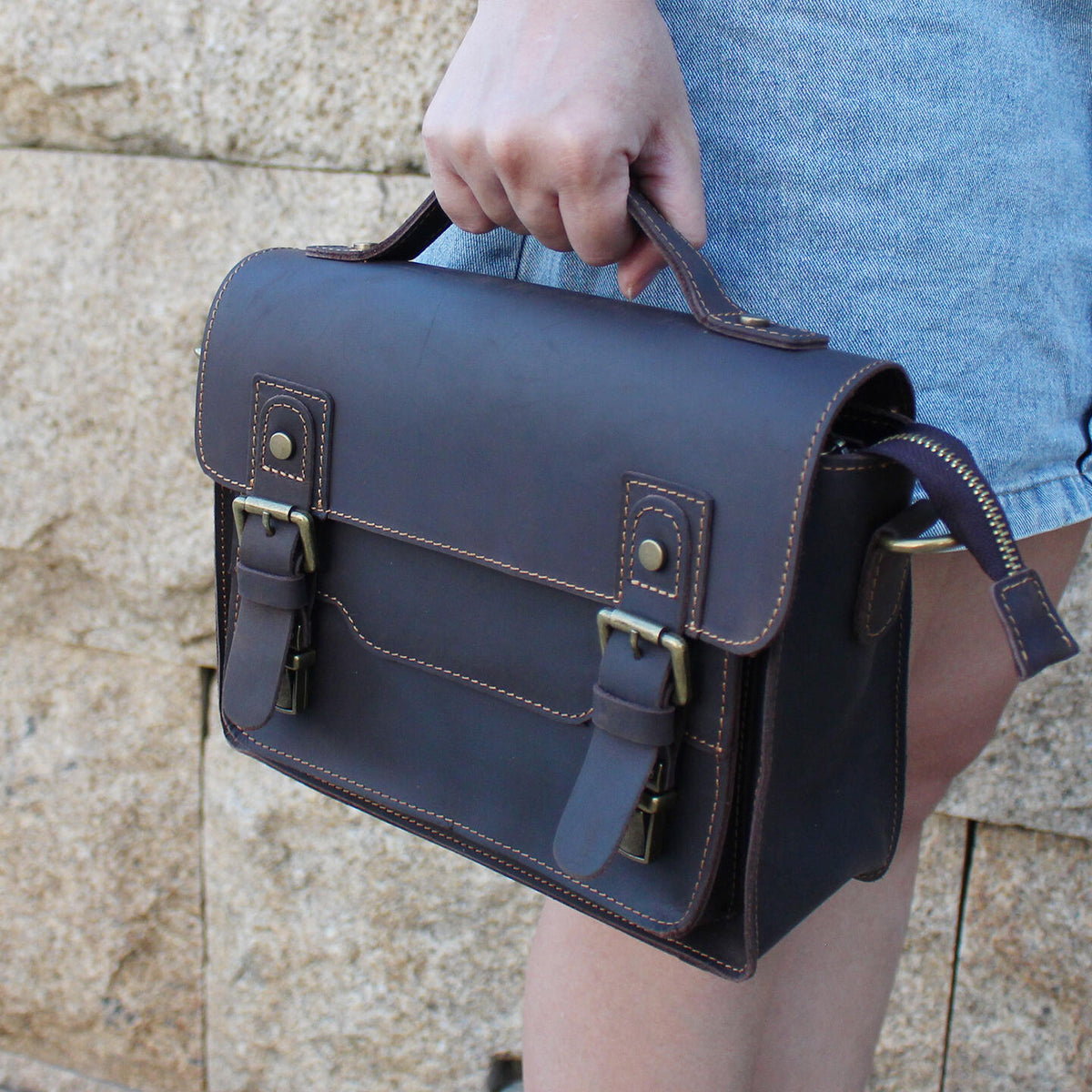 Brown crazy-horse leather messenger satchel carried by its top handle