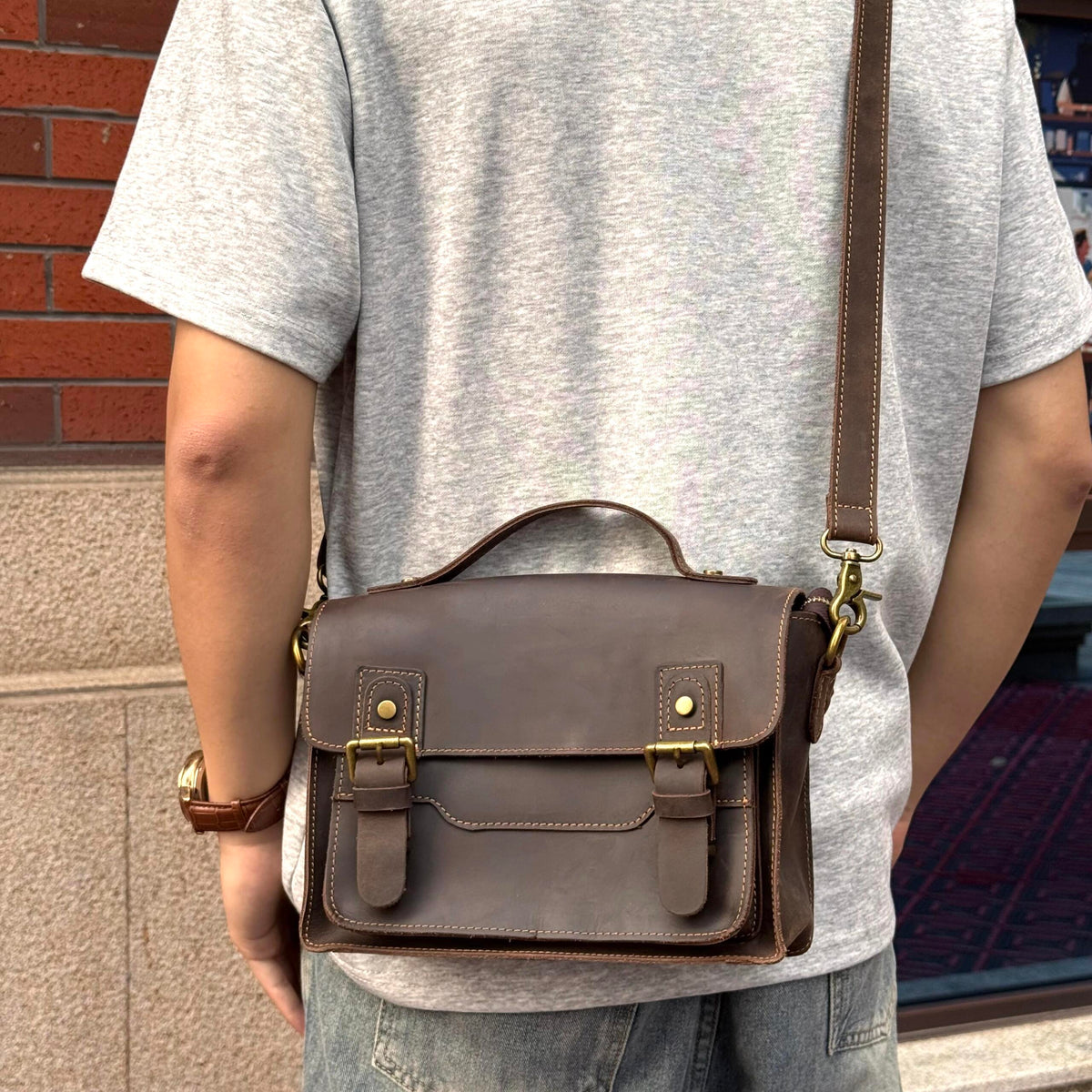 Brown crazy-horse leather messenger satchel worn crossbody outdoors