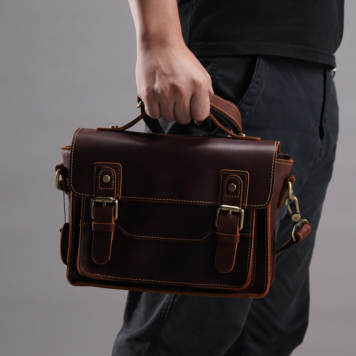 Brown crazy-horse leather messenger satchel carried by the top handle