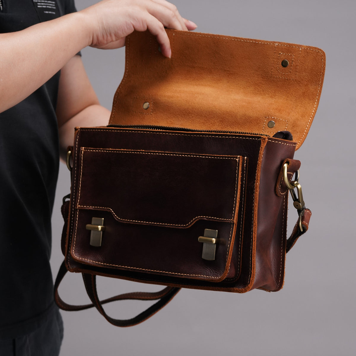 Brown messenger satchel with the flap open to show front storage