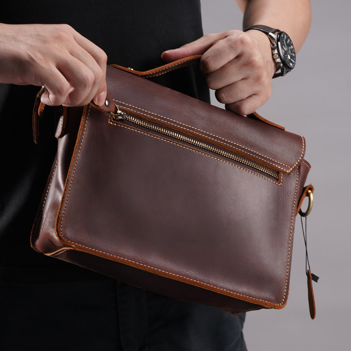 Back view of the brown leather messenger satchel with rear zip access