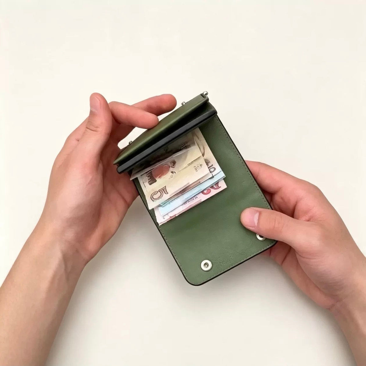 Green trifold wallet holding folded banknotes
