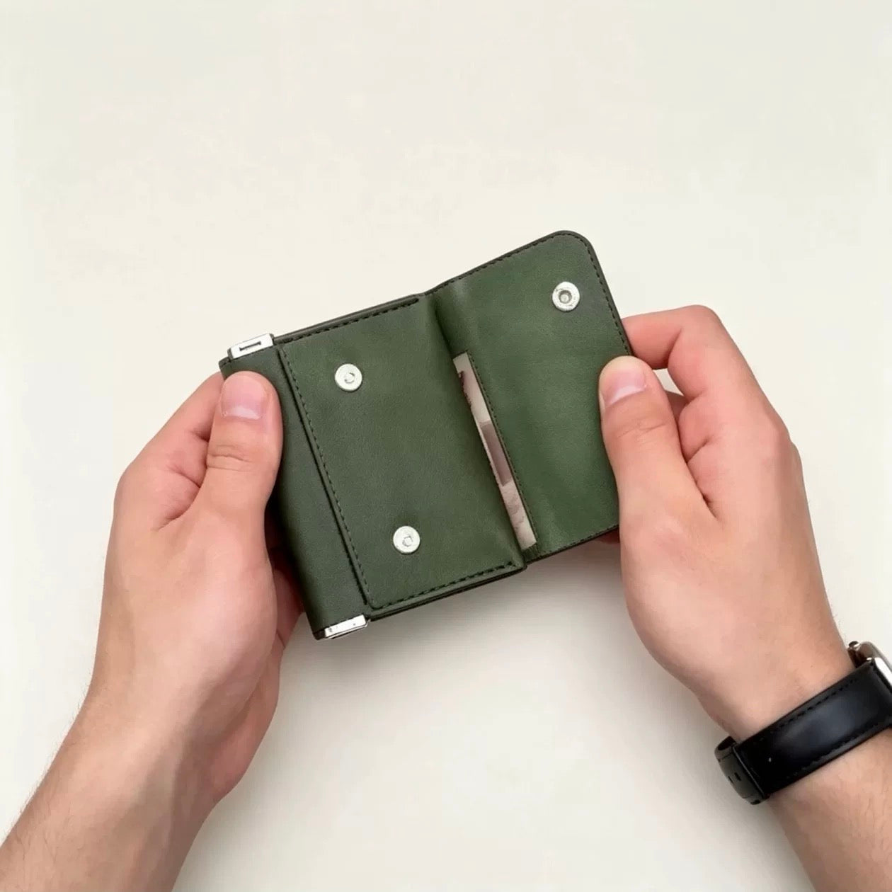 Green trifold wallet opened to show organized interior storage