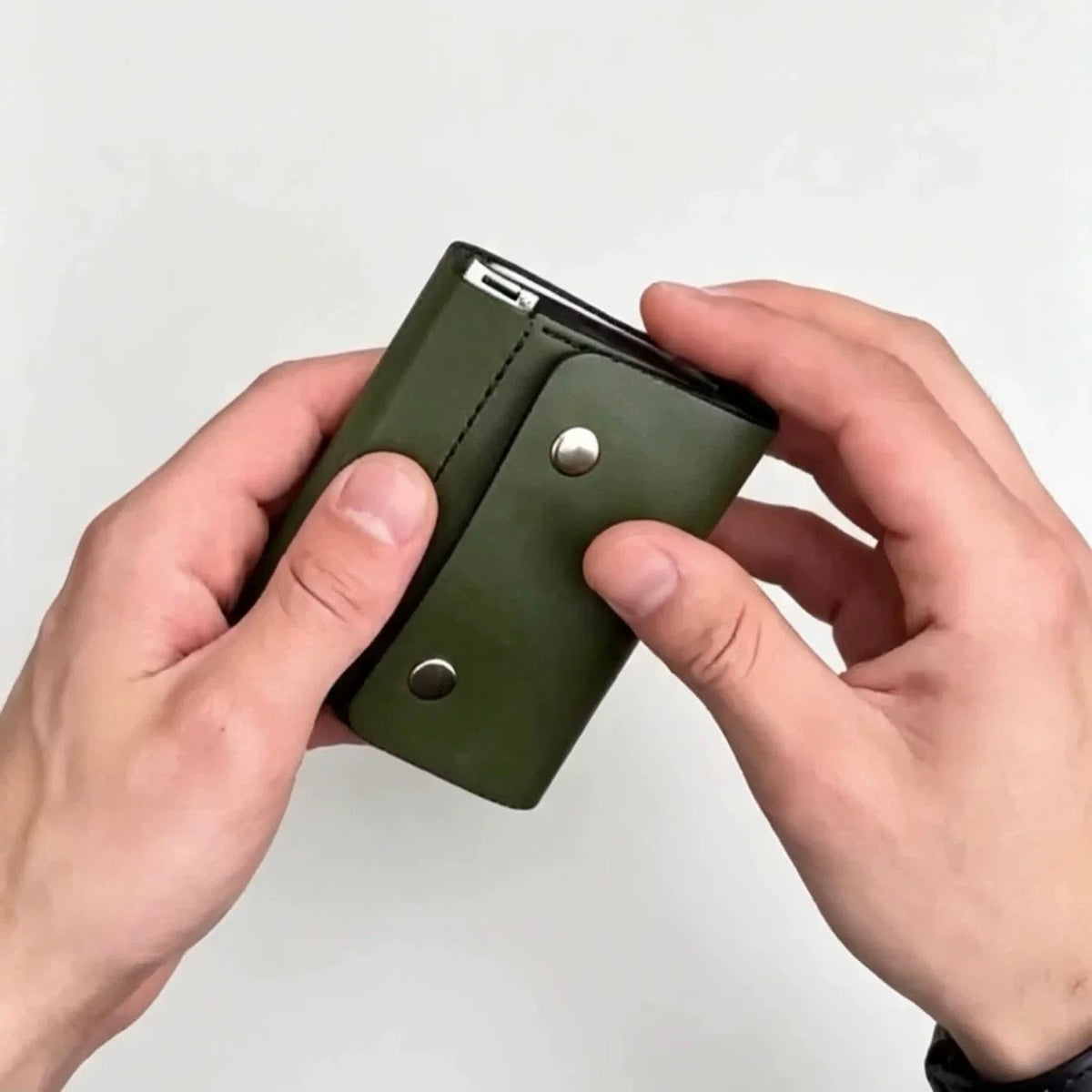 Green trifold wallet snap closure and spring-frame edge detail