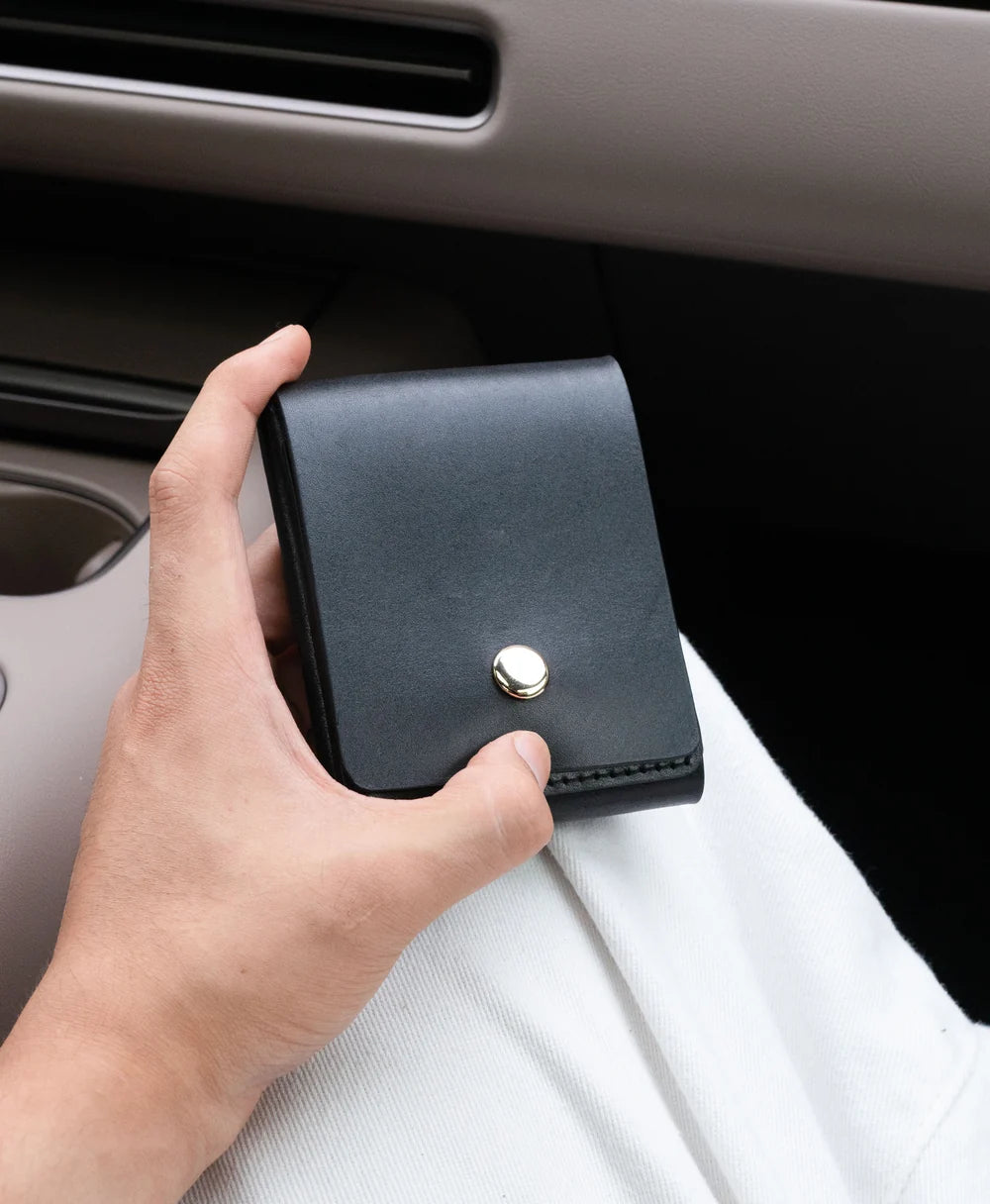 Black vertical snap wallet in hand for quick everyday access