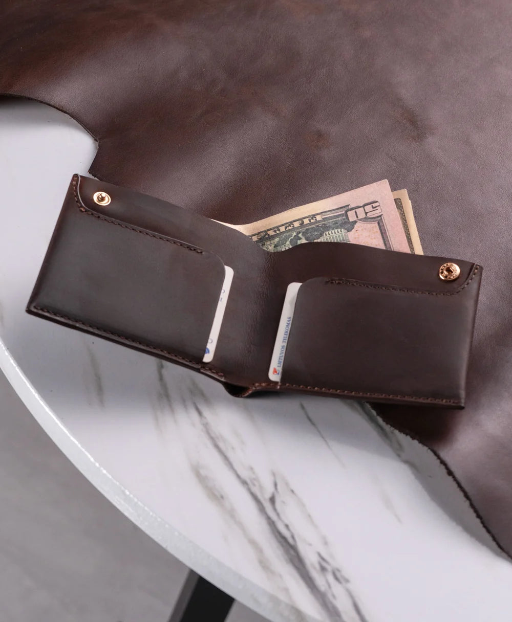 Handmade dark brown bifold wallet carried in hand