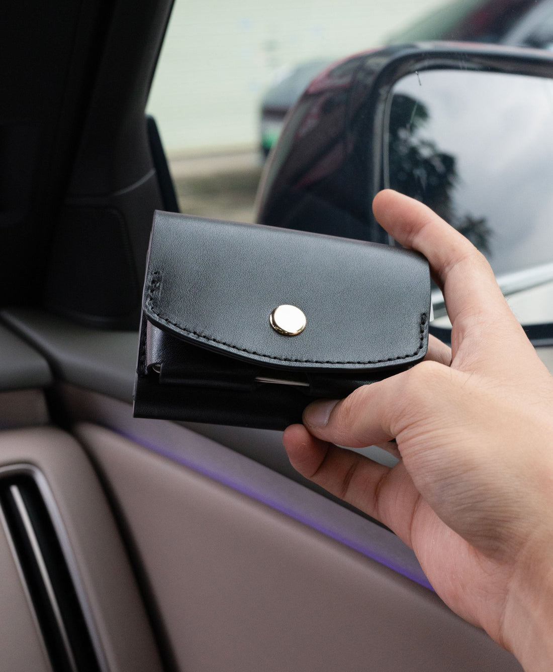 Black full-grain saddle leather trifold wallet in everyday use