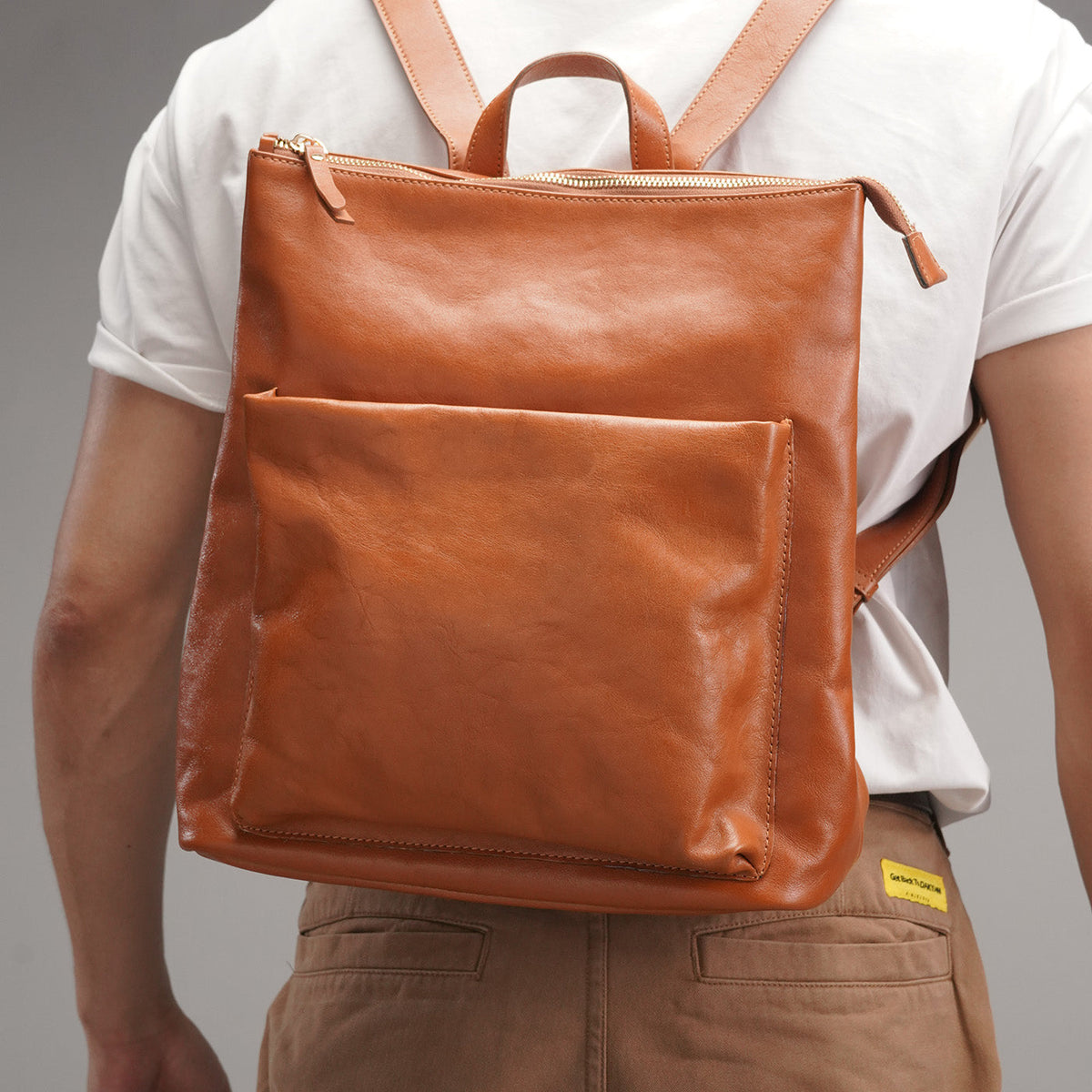 Full-grain leather backpack shown against the wearer for scale