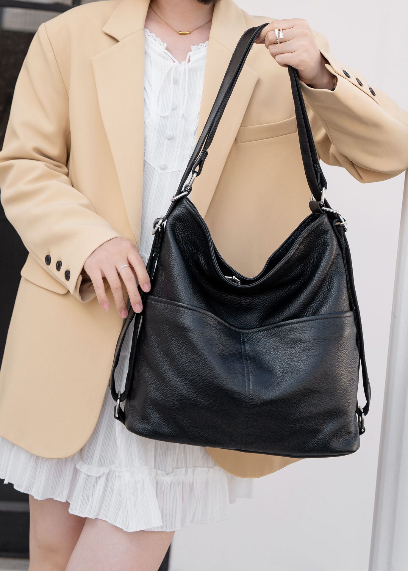Black convertible leather bag shown in tote carry mode
