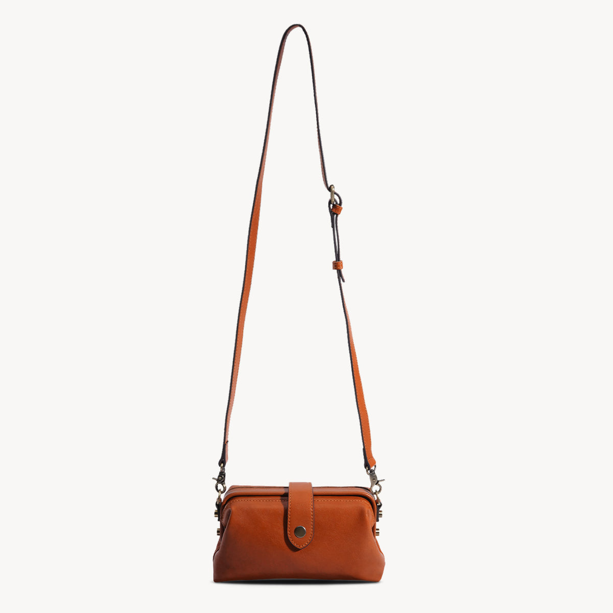 Compact brown leather frame crossbody bag with adjustable shoulder strap