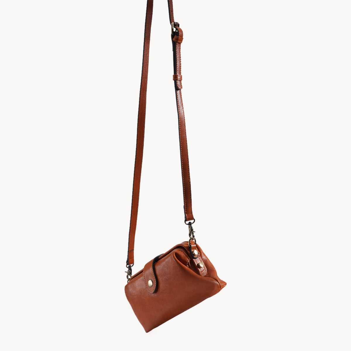Side profile of the compact brown leather crossbody bag