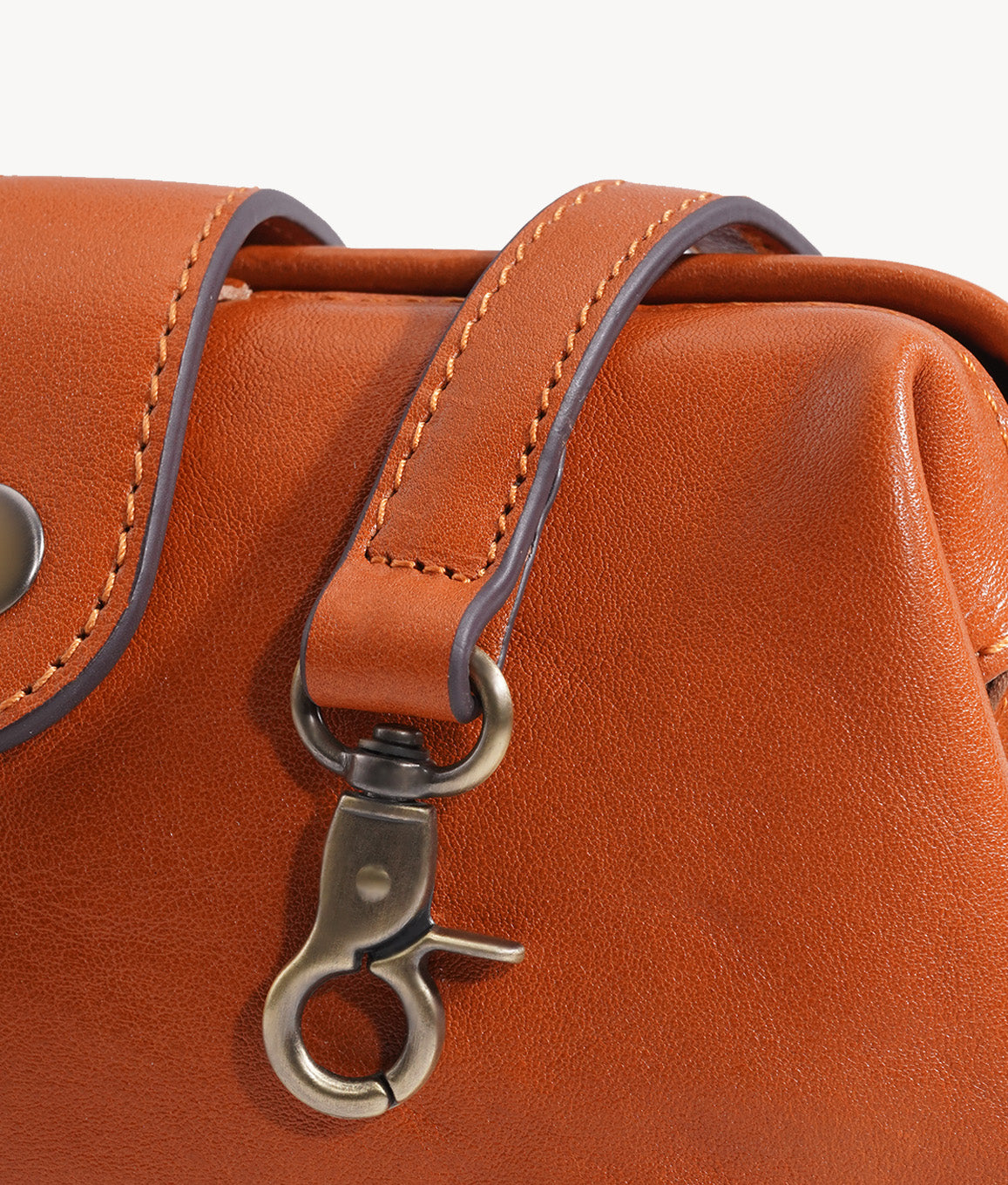 Leather shoulder strap attachment and antique brass-tone hardware detail