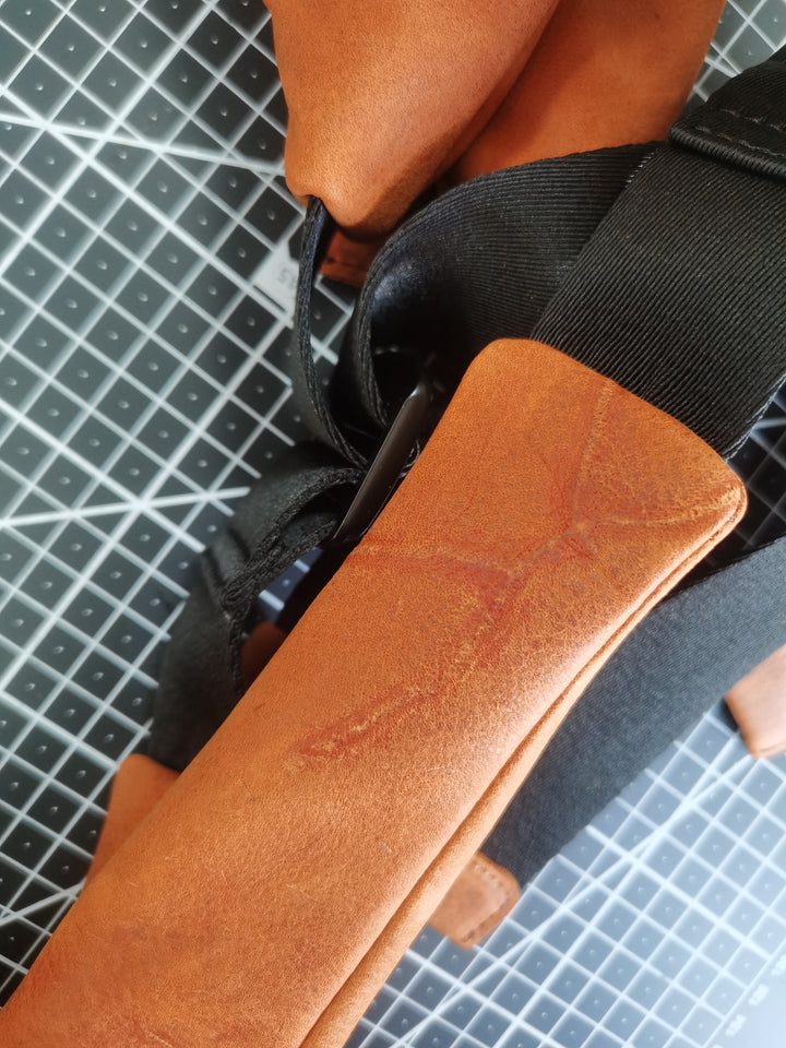 Natural grain and healed marking retained on the finished orange cowhide bag