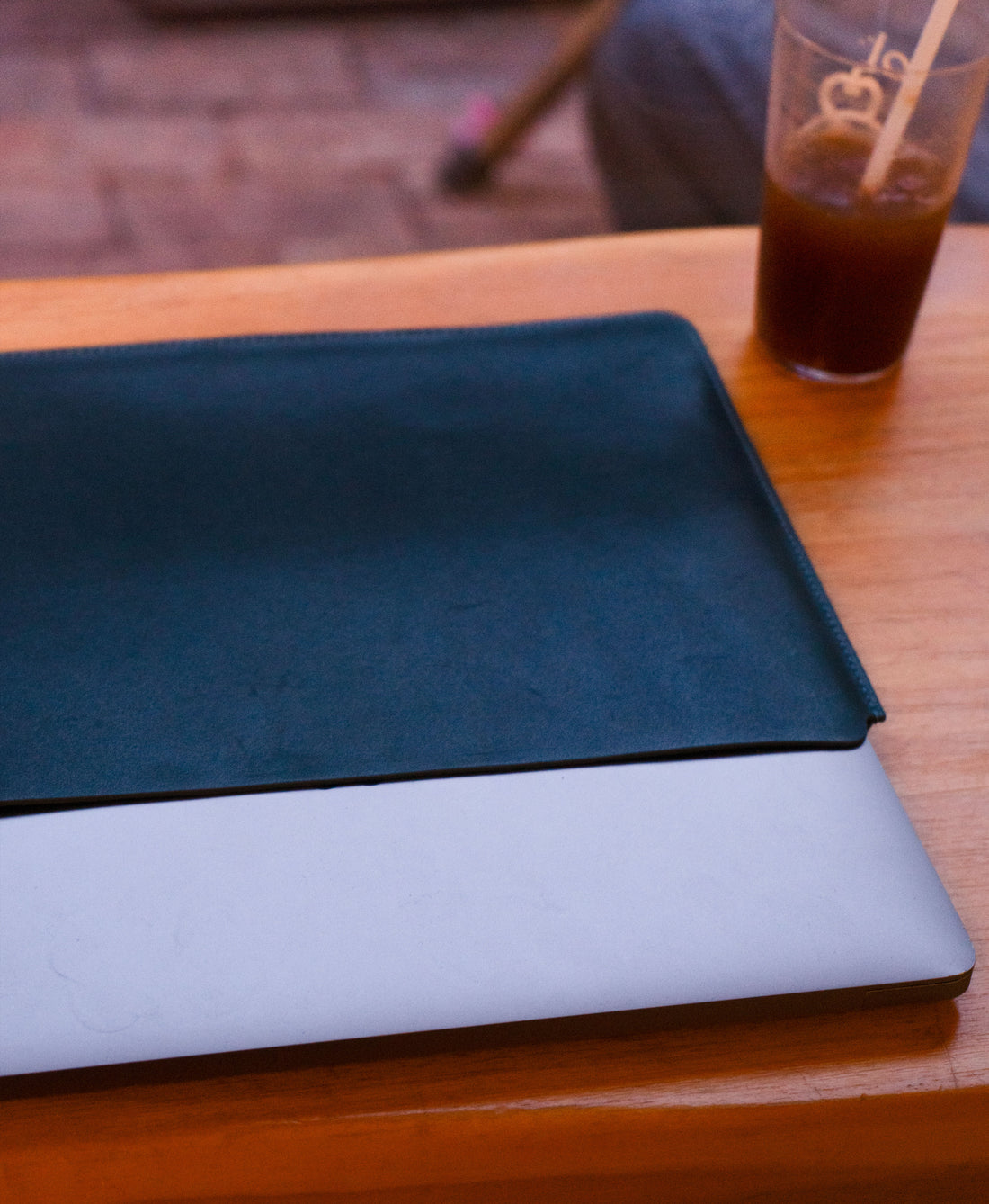 Blue full-grain leather sleeve with a MacBook sliding inside