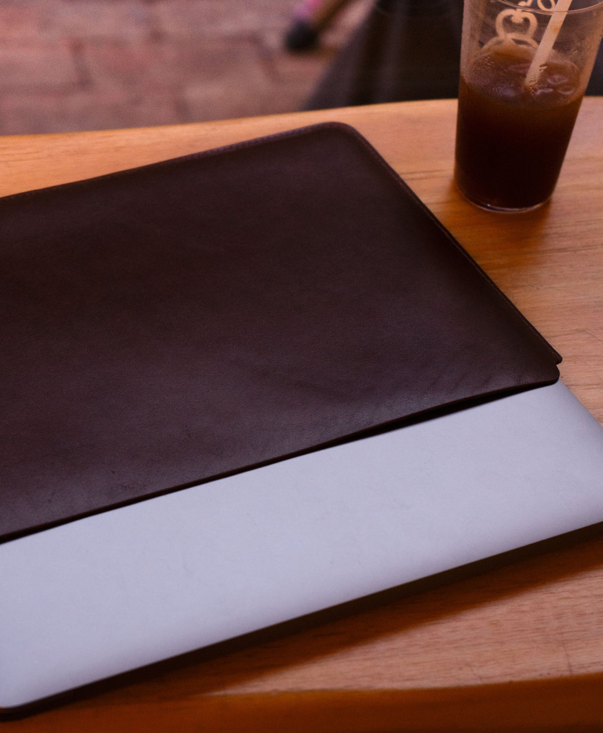 Brown full-grain leather sleeve showing a close MacBook fit
